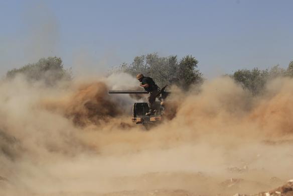 یک عضو ارتش آزاد سوریه به سمت نیروهای حکومتی بشار اسد شلیک می کند (رویترز)